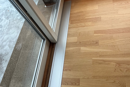 Villa i Holmestrand. E-100 med ramme nedfelt i parkett foran terrassedør. Farge eloksert aluminium (standard).